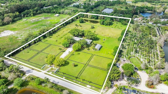 birds eye view of property featuring a water view and a rural view