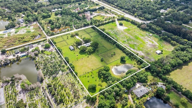 birds eye view of property with a water view and a rural view