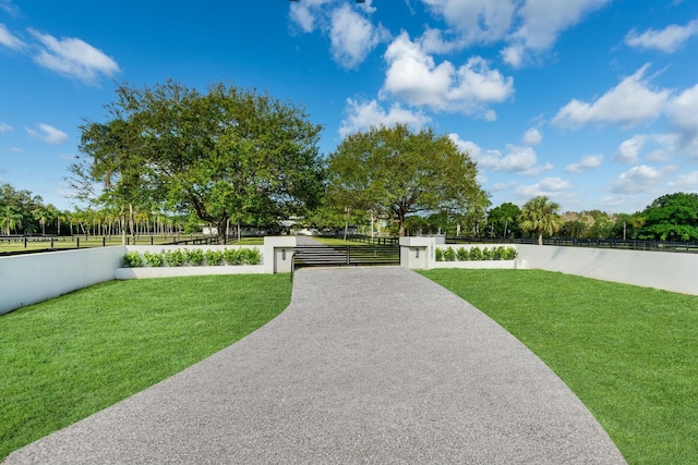 surrounding community featuring a fenced front yard, a gate, and a yard