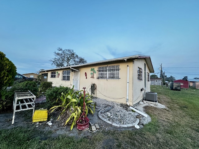 exterior space with a lawn and central air condition unit