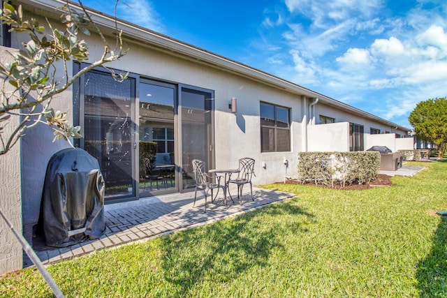 back of property featuring a patio area, fence, a lawn, and stucco siding