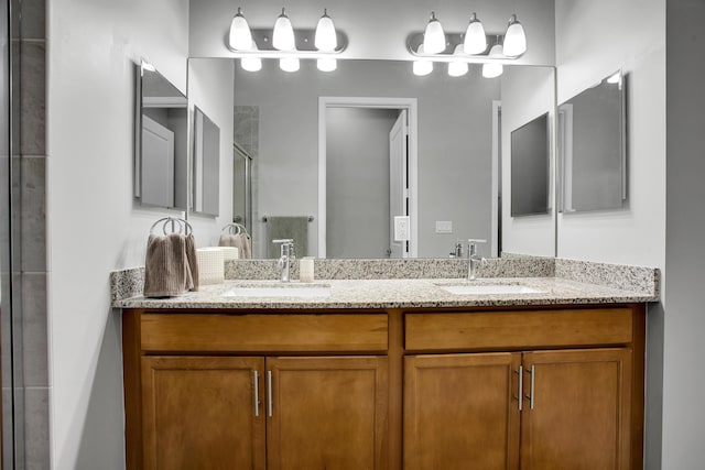 full bathroom with double vanity, a stall shower, and a sink