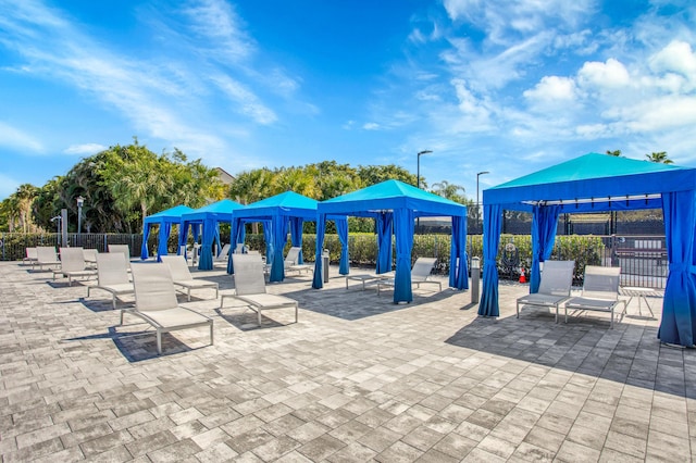 view of property's community with a gazebo, a patio area, and fence