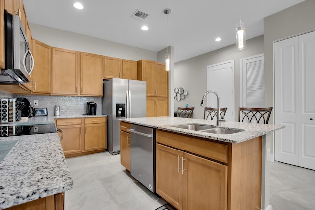 kitchen with visible vents, an island with sink, a sink, stainless steel appliances, and backsplash