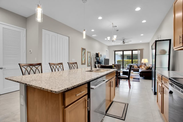 kitchen with a center island with sink, dishwasher, decorative light fixtures, light stone countertops, and recessed lighting