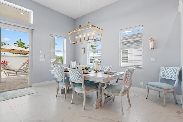 dining space with baseboards, plenty of natural light, and marble finish floor