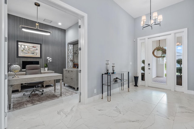 foyer with a notable chandelier, baseboards, a high ceiling, and marble finish floor