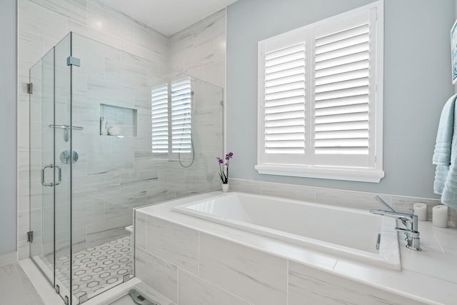 full bathroom featuring a bath and a stall shower