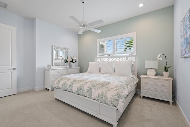 bedroom featuring visible vents, baseboards, light colored carpet, and a ceiling fan