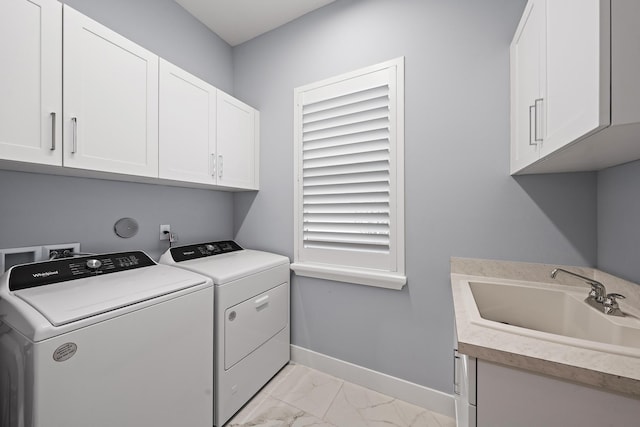 clothes washing area with marble finish floor, washer and clothes dryer, a sink, cabinet space, and baseboards