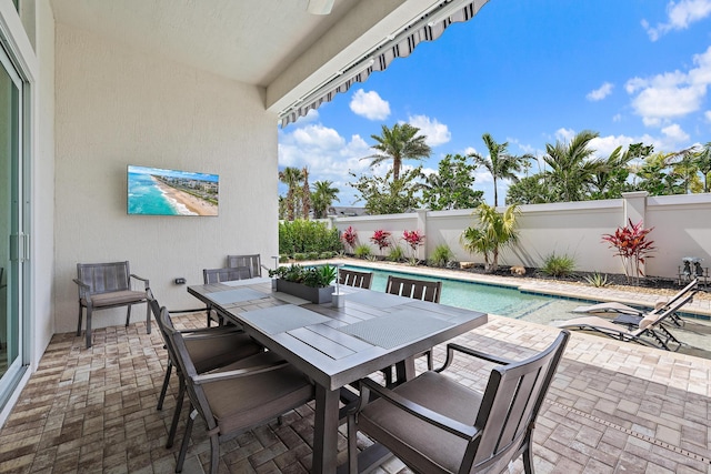 view of patio / terrace featuring outdoor dining space, a fenced backyard, and a fenced in pool