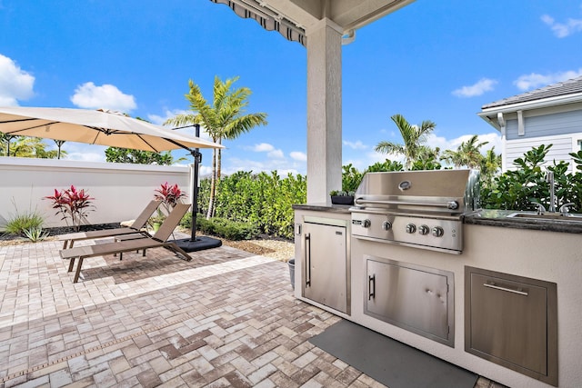 view of patio / terrace with area for grilling and fence