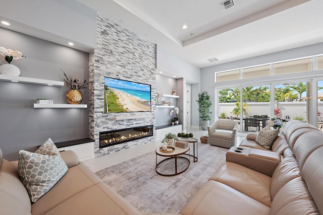 living room with built in features, visible vents, a high ceiling, and a fireplace