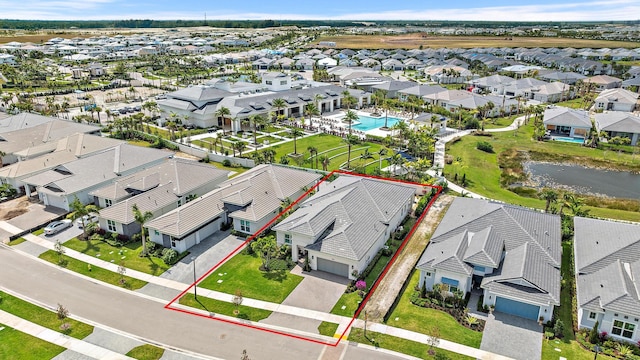 drone / aerial view featuring a residential view and a water view