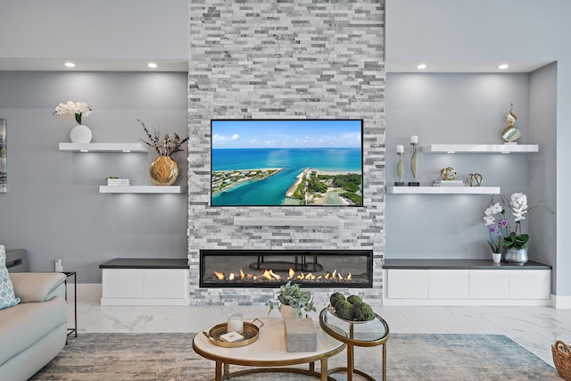 living area featuring a stone fireplace, recessed lighting, and marble finish floor