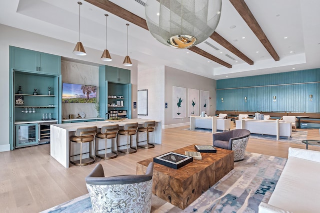 living area with beam ceiling, beverage cooler, and light wood-type flooring