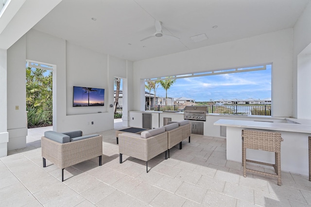 view of patio / terrace with a grill, an outdoor hangout area, exterior kitchen, and a ceiling fan