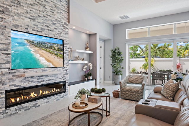 living room featuring visible vents, marble finish floor, and a fireplace