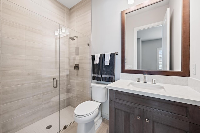 bathroom with vanity, toilet, and a shower stall