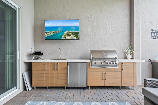 view of patio with a grill, exterior kitchen, and a sink