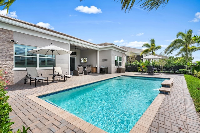 view of pool featuring a fenced in pool, a patio, and a ceiling fan