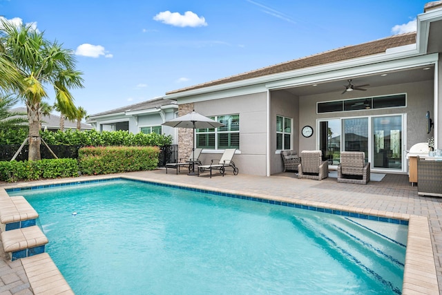 view of swimming pool featuring a patio area, a fenced in pool, and ceiling fan