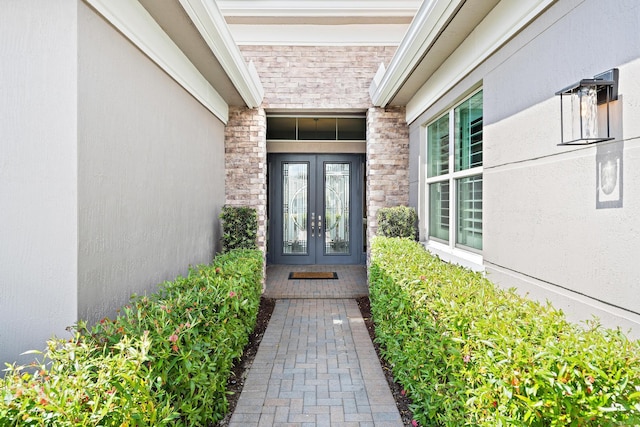 doorway to property with stone siding, stucco siding, and french doors