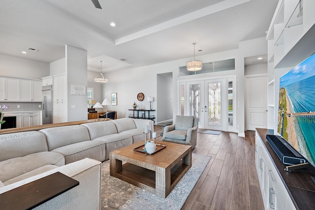 living room with recessed lighting, french doors, and dark wood-type flooring