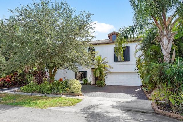 view of front of home featuring an attached garage and decorative driveway