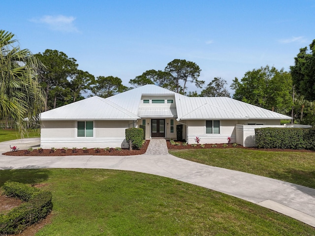 view of front of house featuring driveway, a front yard, french doors, and stucco siding