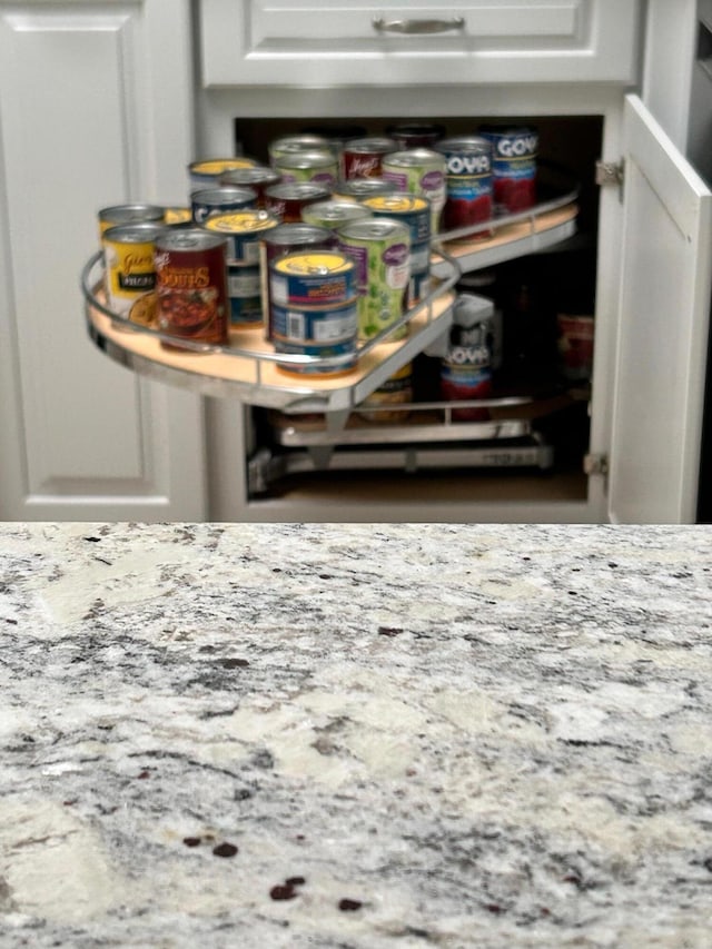 details featuring light stone countertops and white cabinets