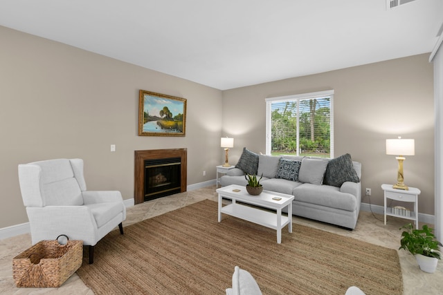 living room featuring a glass covered fireplace and baseboards