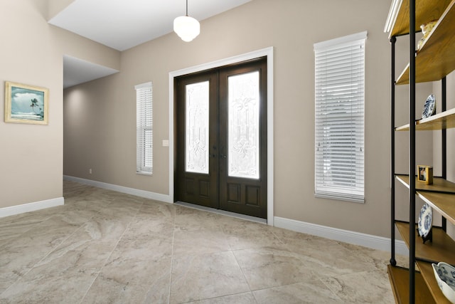 foyer entrance with french doors and baseboards