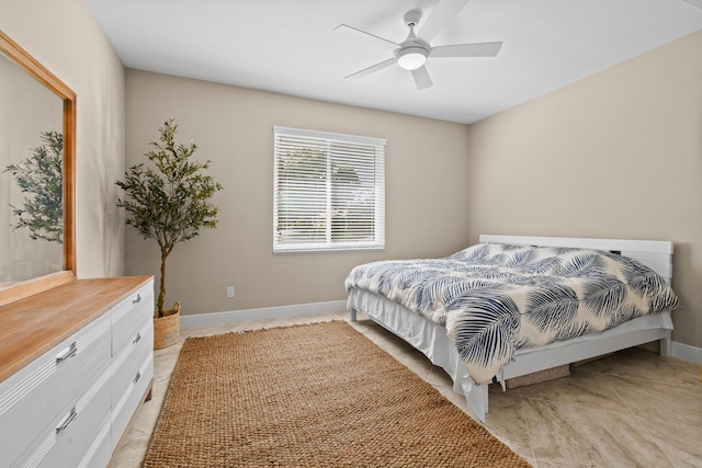 bedroom with a ceiling fan and baseboards