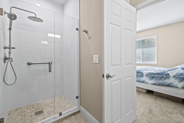 bathroom featuring a shower stall and baseboards