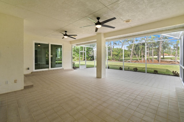 view of patio with glass enclosure and a ceiling fan