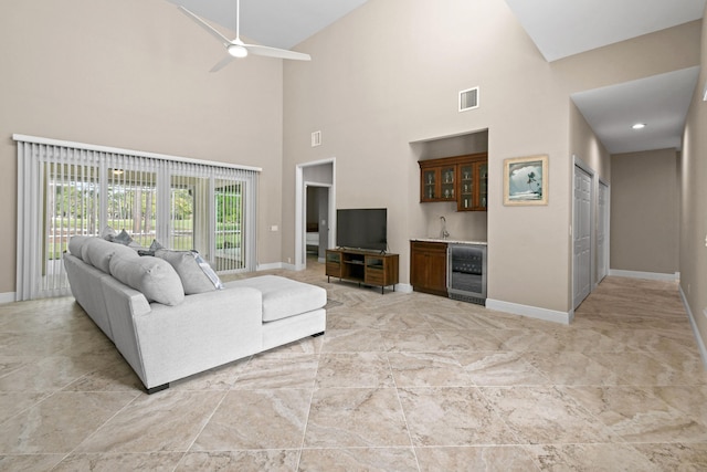 7250 Reserve Creek Dr, Port Saint Lucie, FL 34986 - living room with bar with sink, wine cooler, high vaulted ceiling, a ceiling fan, and light marble finish floors