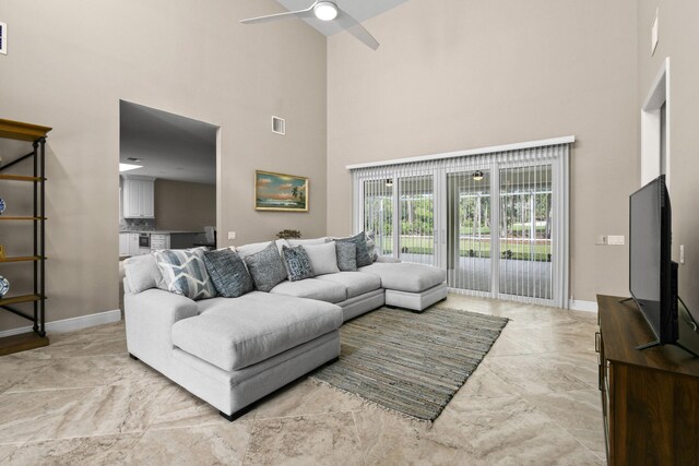 living room with a high ceiling, visible vents, and baseboards