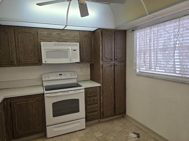 kitchen featuring light countertops, white appliances, dark brown cabinetry, and baseboards