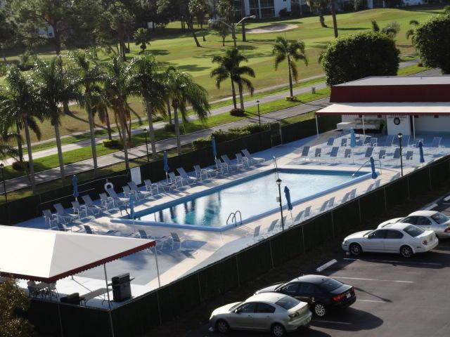 pool featuring view of golf course and fence