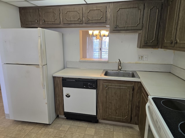 kitchen with white appliances, dark brown cabinets, light countertops, and a sink