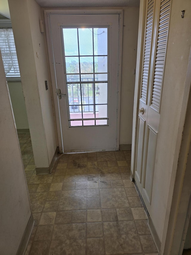 doorway to outside with baseboards