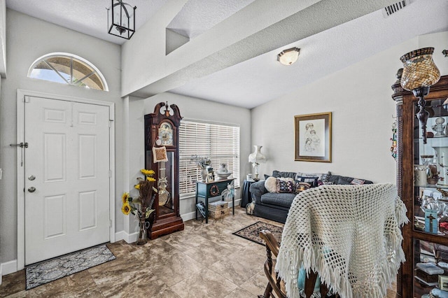 entryway with a healthy amount of sunlight, visible vents, a textured ceiling, and lofted ceiling