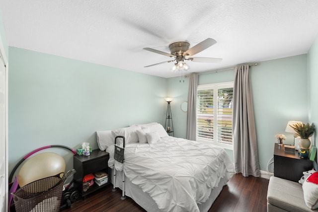 bedroom featuring dark wood finished floors, a textured ceiling, and ceiling fan