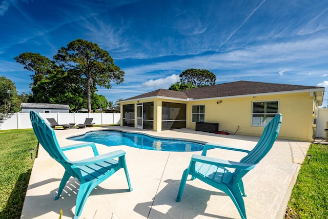 view of swimming pool featuring a lawn, a fenced in pool, a sunroom, a fenced backyard, and a patio area