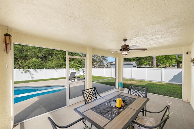 exterior space featuring a ceiling fan, outdoor dining space, a fenced in pool, and a fenced backyard