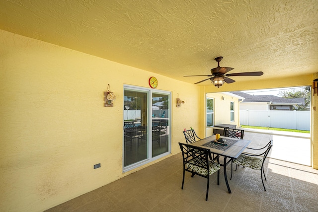 view of patio / terrace with fence, a ceiling fan, and outdoor dining space