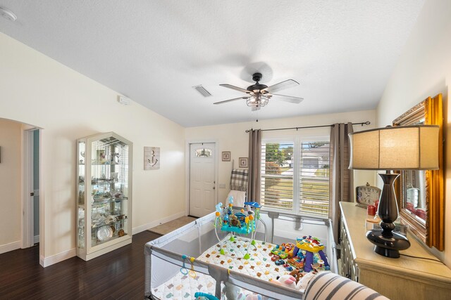 game room with lofted ceiling, visible vents, baseboards, a ceiling fan, and dark wood-style floors