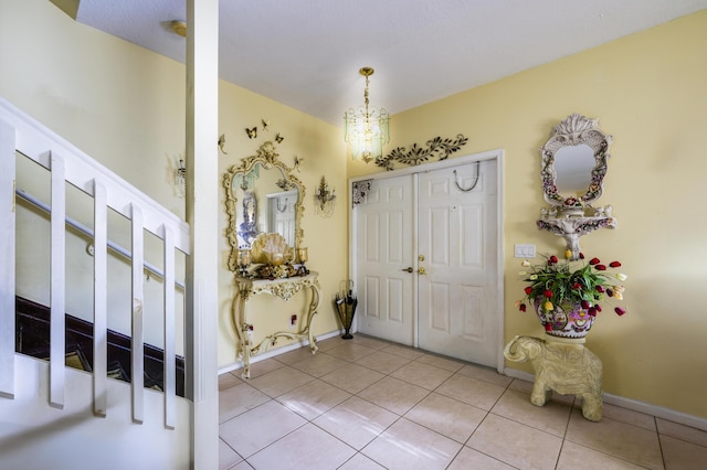 entryway featuring an inviting chandelier, baseboards, and light tile patterned floors