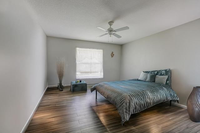 bedroom with a ceiling fan, a textured ceiling, baseboards, and wood finished floors